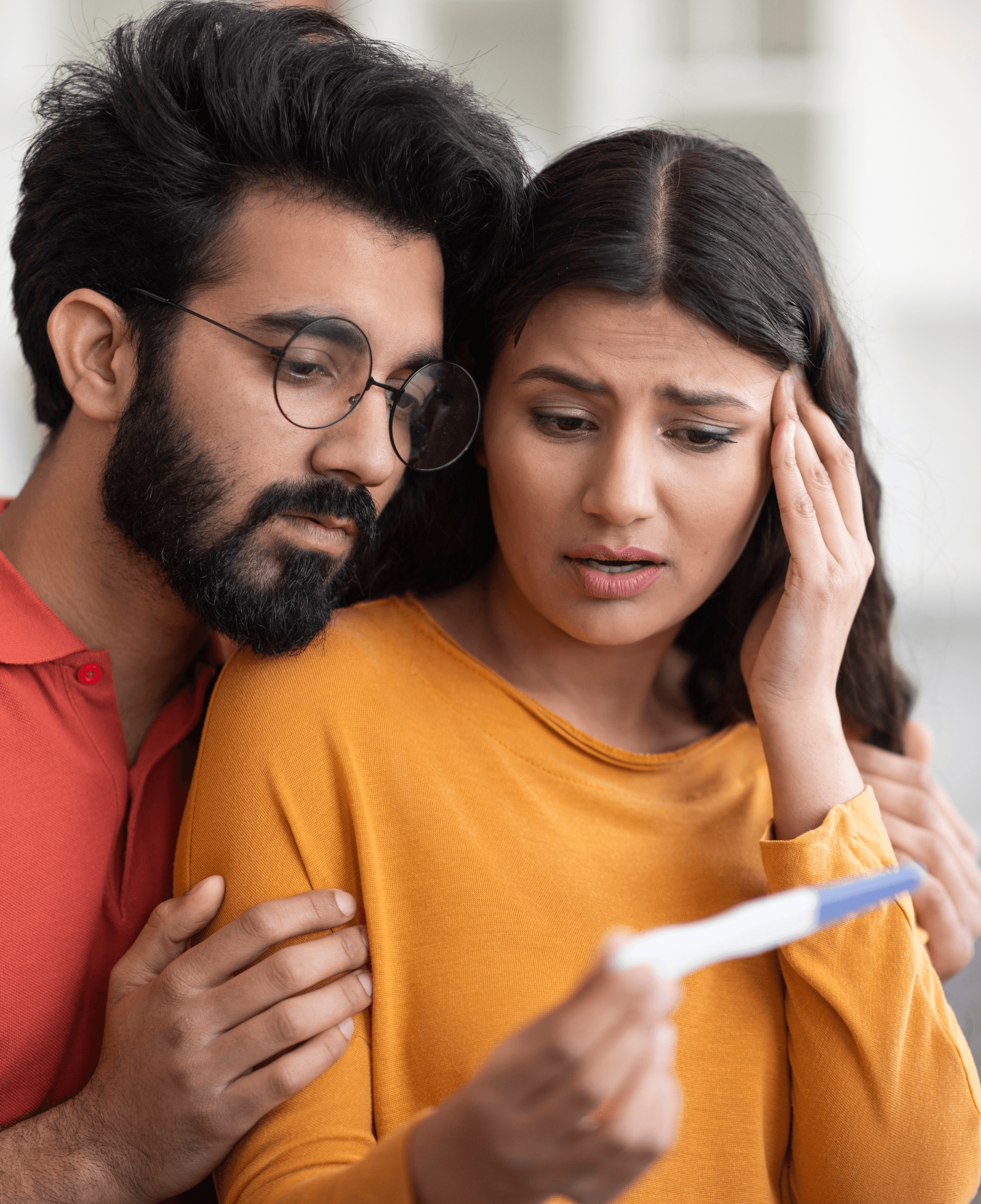 Couple looking at pregnancy test, concerned